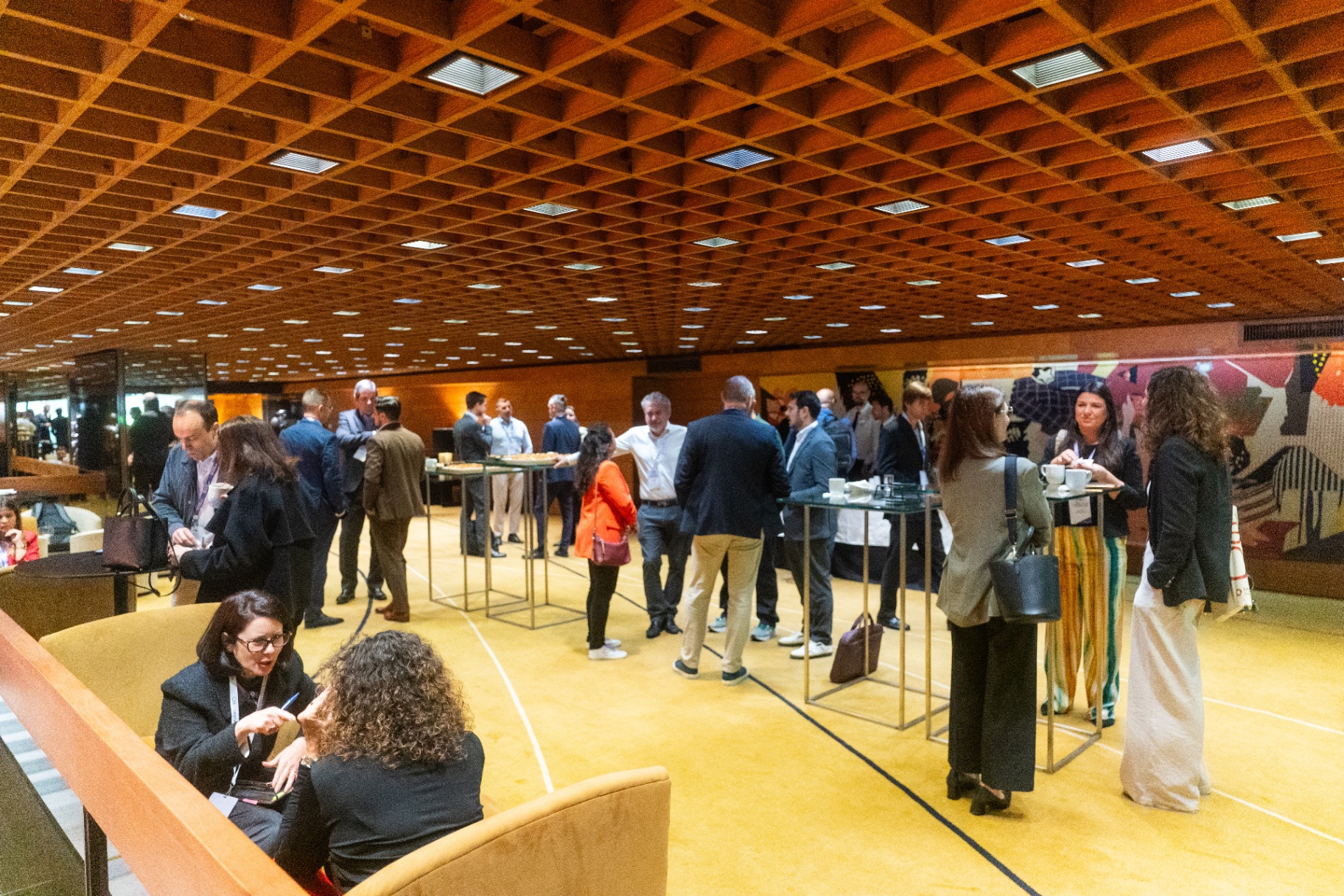 Delegates networking on the exhibition floor at a sponsor booth.